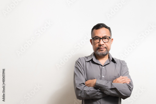 40-50 years old Asian businessman folded his arms and smiled happily after successfully investing in finance, banking, real estate, oil, petroleum. Copy space on left, Blurred, White background photo