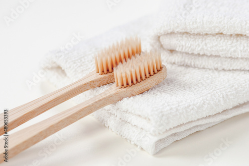 Plant-based bristle bamboo toothbrushes on white towel, organic biodegradable toothbrush closeup