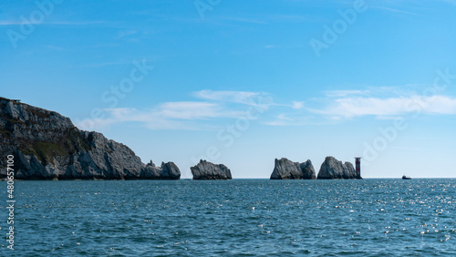 View of Slow Cruise Boat Next to The Needles Lighthouse and chalk rocks in Alum Bay, Isle of Wight, United Kingdom