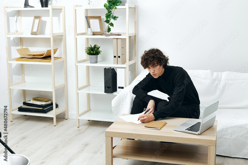 teenager sitting on the couch at the table in front of a laptop communication