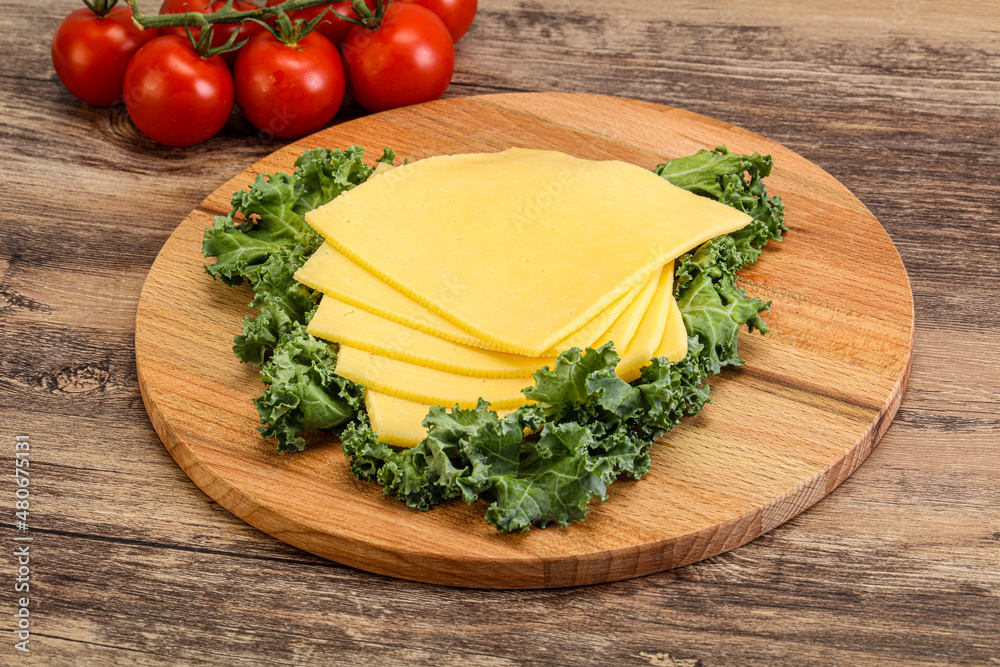 Sliced Gauda cheese over board Sliced Gauda cheese over board