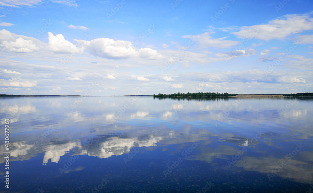 Clouds on a blue sky with reflection in water Clouds on a blue sky with reflection in water