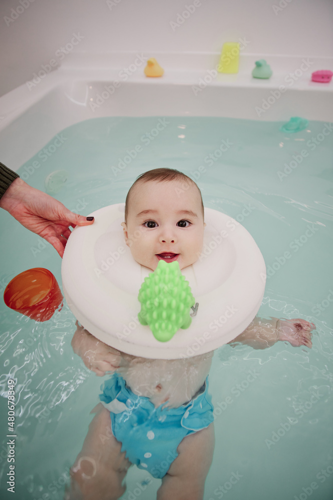 Baby enjoying in the jacuzzi. Spa for babies. Hydrotherapy session for children. Baby swimming Baby enjoying in the jacuzzi. Spa for babies. Hydrotherapy session for children. Baby swimming