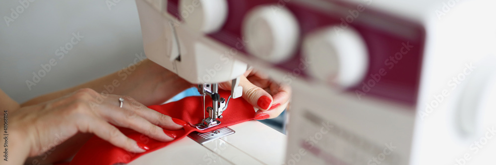 Woman seamstress sews a seam on a sewing machine