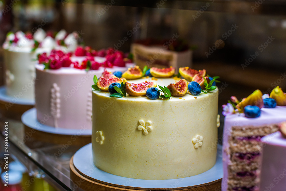 showcase with cakes. appetizing sweets with fruits and berries, figs, blueberries, raspberries