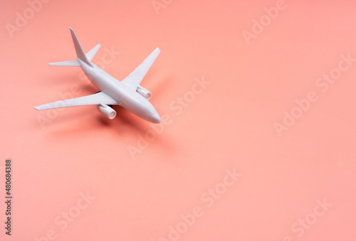 White clean Plane model on pastel pink color background with copy space, minimal style. White airplane, close up. Flight, travel concept.