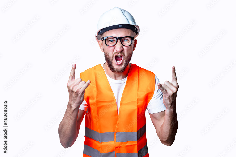 Young male construction worker showing rocker goat sign on light background. Young male construction worker showing rocker goat sign on light background.