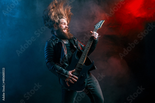 Canvastavla Expression rock guitar player with long hair and beard plays on the smoke background