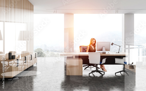 Young office woman in manager room with computer and panoramic windows
