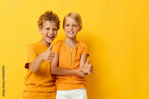 Cute stylish kids in yellow t-shirts standing side by side childhood emotions isolated background unaltered