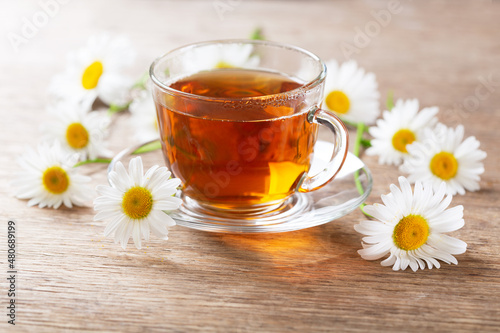 cup of herbal chamomile tea with fresh flowers