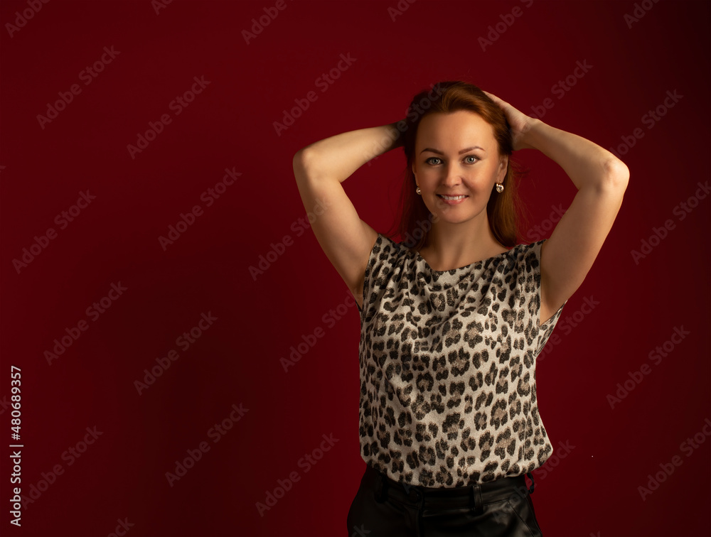 a modern stylish girl with golden hair in leather trousers and a spotted blouse on a red background a modern stylish girl with golden hair in leather trousers and a spotted blouse on a red background
