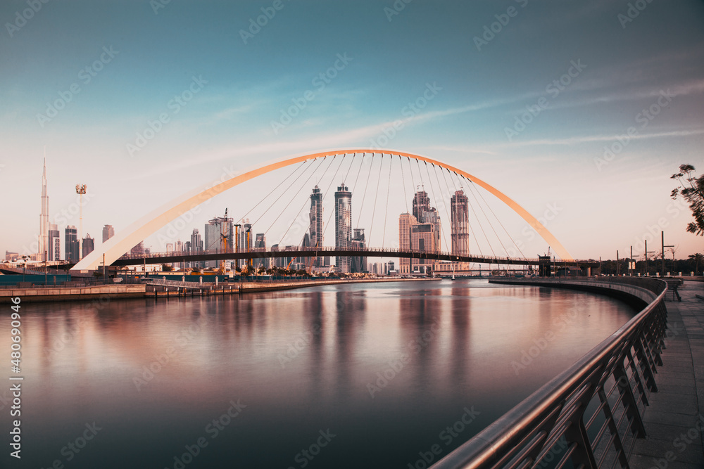 Fototapeta premium DUBAI, UAE - FEBRUARY 2018: Colorful sunset over Dubai Downtown skyscrapers and the newly built Tolerance bridge as viewed from the Dubai water canal.