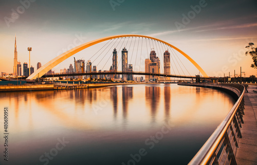 DUBAI, UAE - FEBRUARY 2018: Colorful sunset over Dubai Downtown skyscrapers and the newly built Tolerance bridge as viewed from the Dubai water canal.