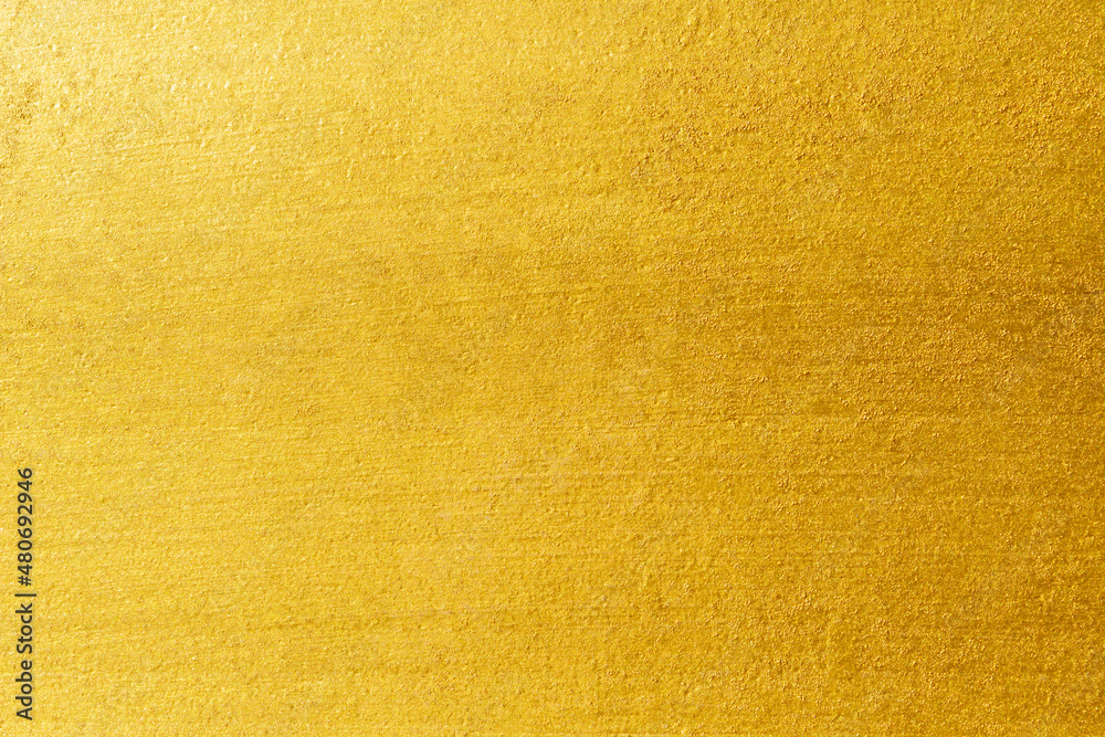 Gold wall texture background. Yellow shiny gold foil on concrete wall surface, vibrant golden luxury wallpaper Gold wall texture background. Yellow shiny gold foil on concrete wall surface, vibrant golden luxury wallpaper