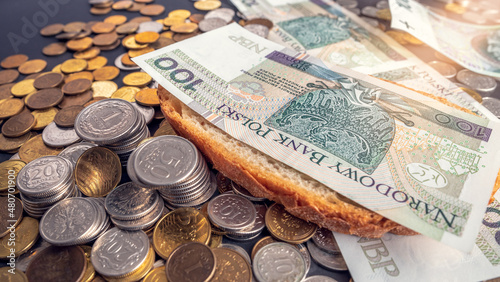 Fotografie PLN 100 banknote placed on a slice of bread