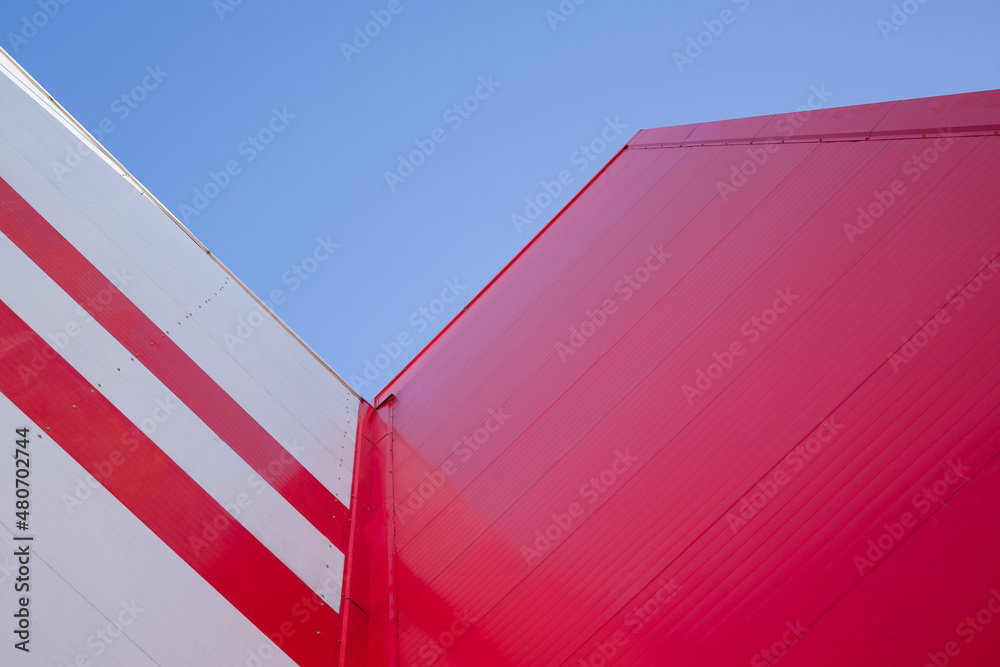 Low Angle View Of Modern Office Building with Red Facade against blue sky