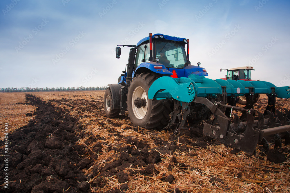 Modern tractor in the field during planting. The concept of agricultural industry. Modern tractor in the field during planting. The concept of agricultural industry.