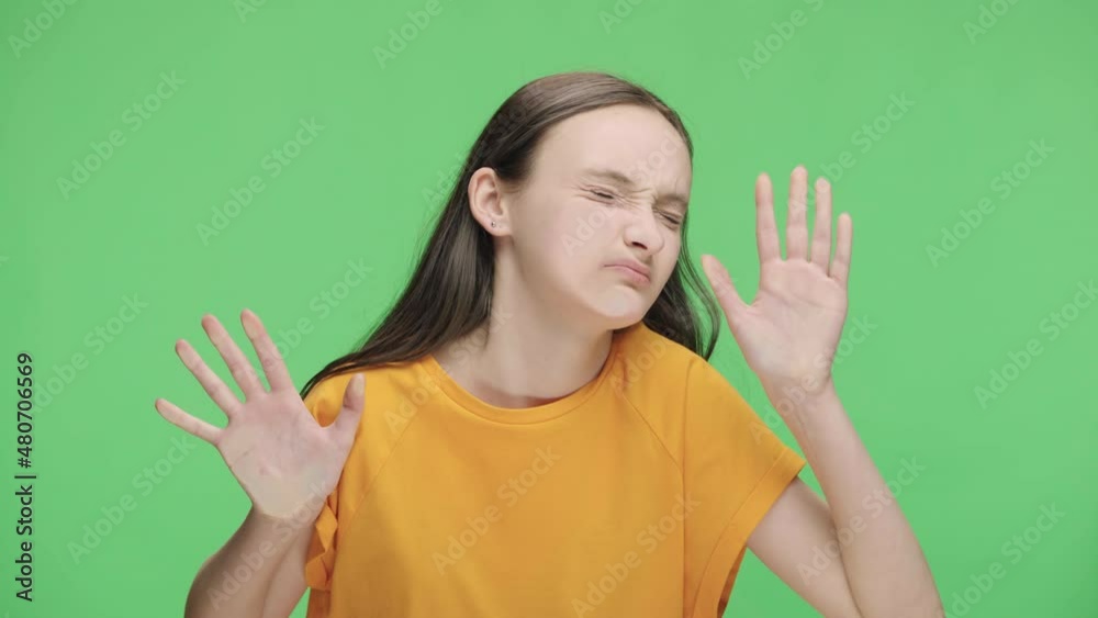 Young girl imitate huddle in public transport and indignantly press their faces and hands against glass. Female model are posing in studio against the background of green screen. Close up. Slow motion Young girl imitate huddle in public transport and indignantly press their faces and hands against glass. Female model are posing in studio against the background of green screen. Close up. Slow motion