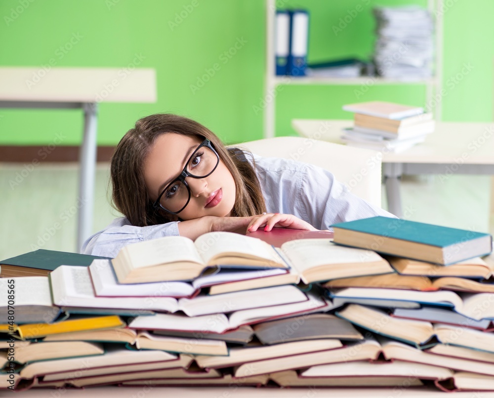 Young female student preparing for exams with many books Young female student preparing for exams with many books