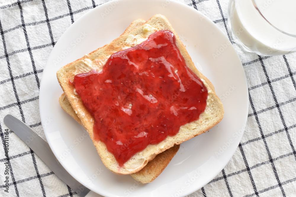 Toast with raspberry jam and butter on a plate. Lovely breakfast at home. Food from above concept. Toast with raspberry jam and butter on a plate. Lovely breakfast at home. Food from above concept.