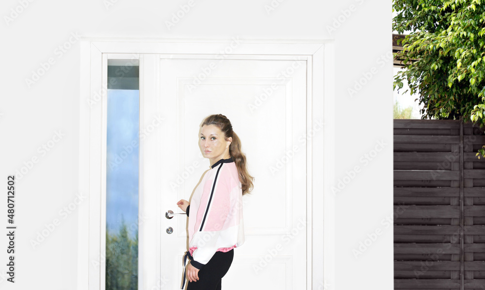 Beautiful woman opening the door of her home Beautiful woman opening the door of her home