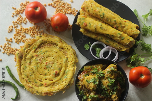 Besan chilla rolls or chickpea pancake rolls. These are protein rich savoury pancakes made of besan flour or chick pea flour with onions, tomato and other vegetables photo