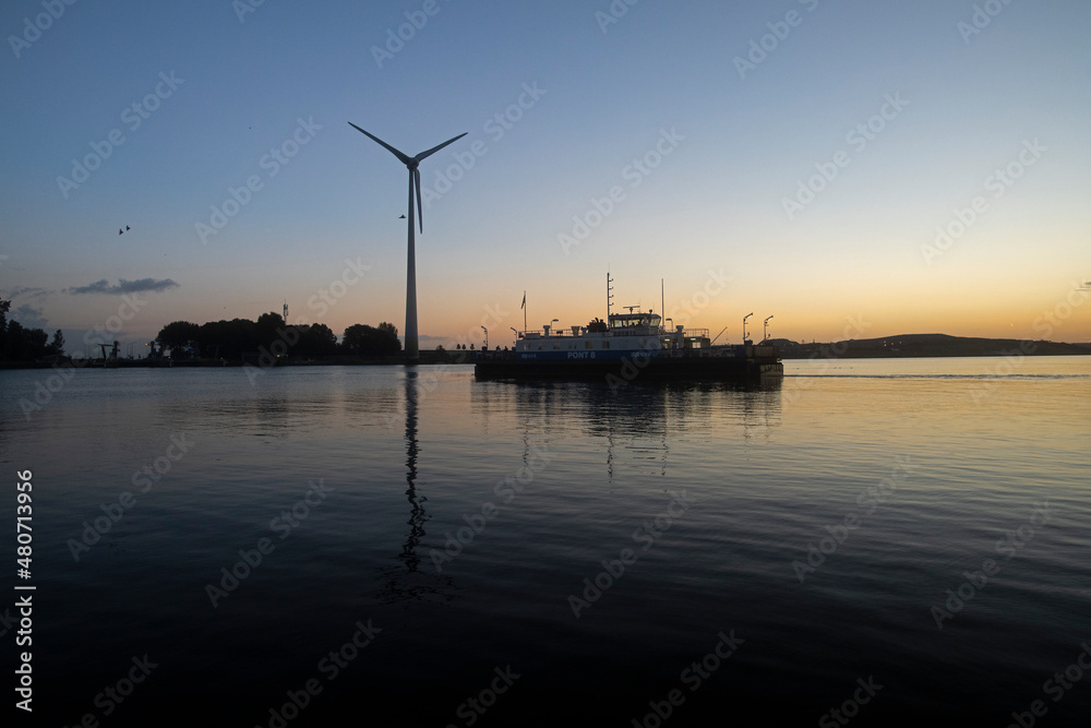 Ferry crossing a river at dawn sunrise