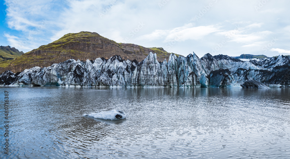 Sólheimajökull picturesque glacier in southern Iceland. The tongue of this glacier slides from the volcano Katla. Beautiful glacial lagoon with blocks of ice and surrounding mountains.