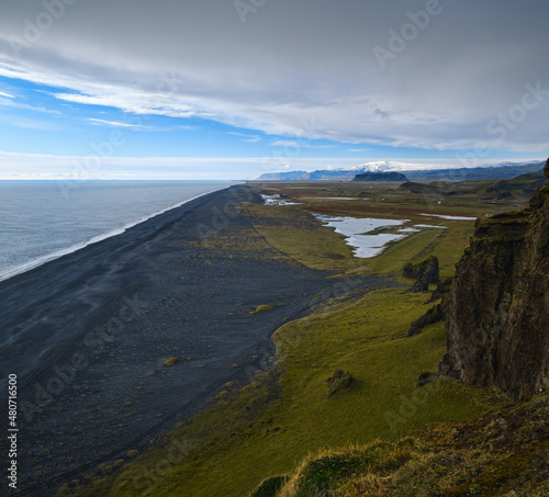 Picturesque autumn evening view to endless ocean black volcanic sand beach from Dyrholaey Cape Viewpoint, Vik, South Iceland.