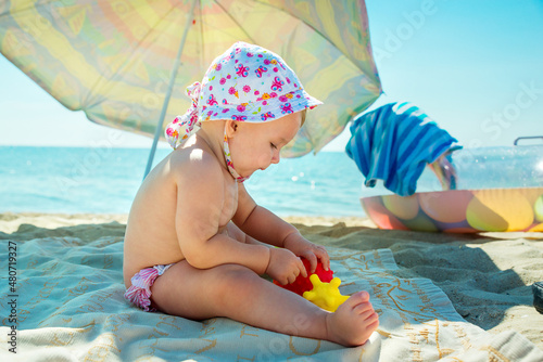 Children play on a tropical beach. Children play on the sea on summer family vacation. Sand and water toys, sun protection for small children.