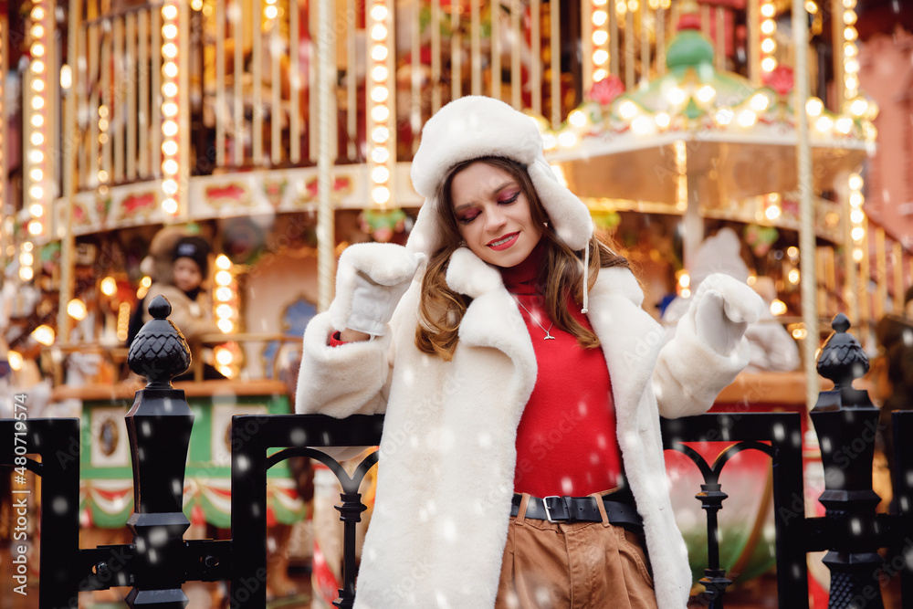 Concept winter holidays christmas europe city. Portrait Happy woman in wearing white stylish warm clothes, bokeh lights