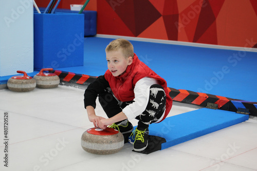 boy playing curling in a sports club