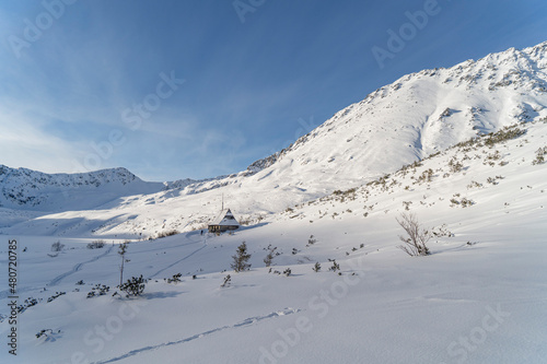 Mountain winter landscape in the Tatras, trail trampled in the snow overlooking the snow-capped mountains in frosty sunny weather Tatras Poland