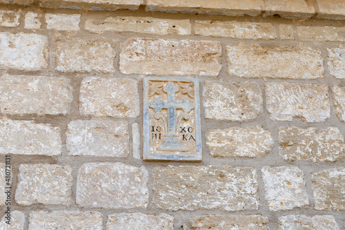 The bas-relief depicting a cross on wall above the entrance to St. John the Baptist Monastery of the Franciscan Order near Israeli side of of Qasr El Yahud, in the Palestinian Authority, in Israel