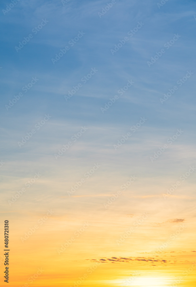 Sunset sky vertical in the evening with colorful orange sunlight clouds on golden hour 