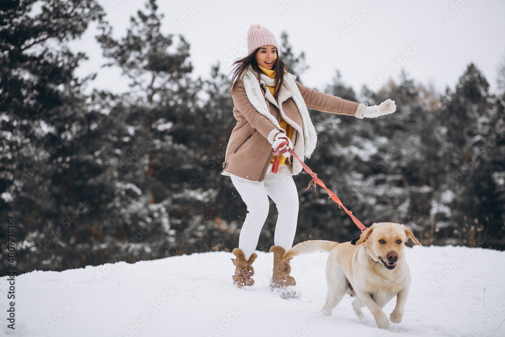 Young woman walking with her dog in a winter park Young woman walking with her dog in a winter park