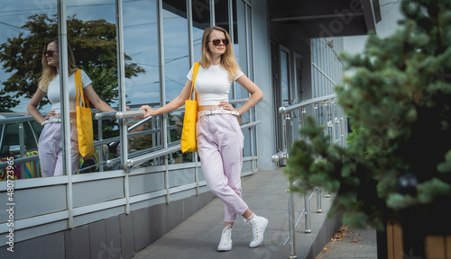 Young beautiful woman with linen eco bag on city background.