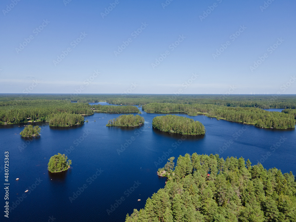 Aerial view of blue lakes and green forests on a sunny summer day in Finland. Drone photography. Ecosystem and healthy environment concepts and background...