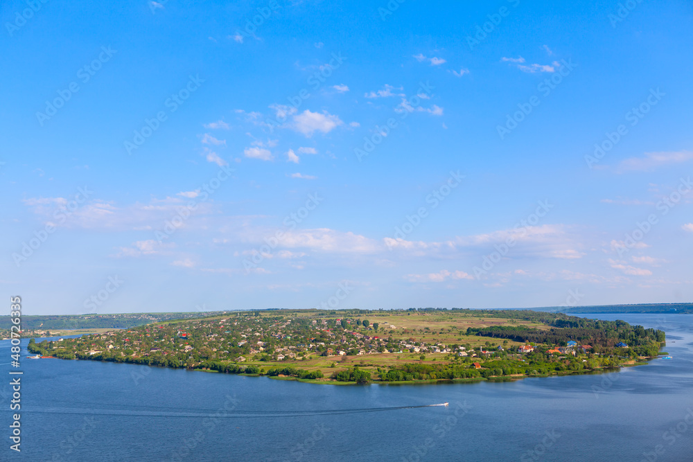 Fototapeta premium Village situated on the island . Green island surrounded by a river