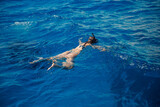 Woman swimmer with mask and snorkel is engaged in snorkeling in red sea, turquoise clear water. Concept Travel Egypt Hawaii