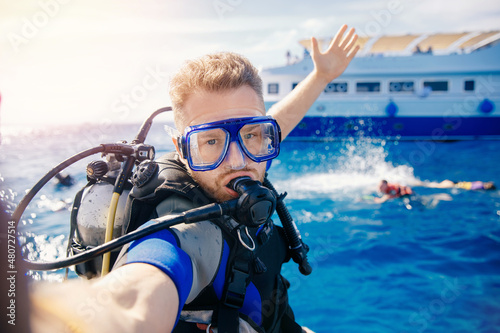 Fotografija Selfie photo man diver scuba diving blue water sea looking at camera with sun light