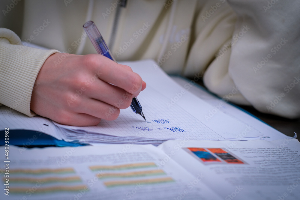  child does his math homework with a fountain pen