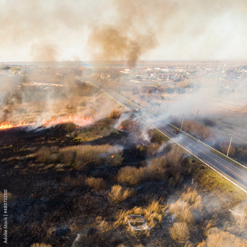 spring dry grass fire next to a busy highway; photo taken from a drone