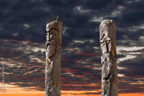 Northern lands. A pagan temple in the taiga with two wooden idols. The image of pagan gods is carved on wooden logs. photo
