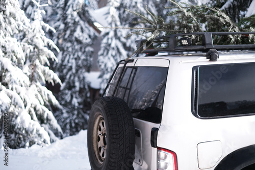 sport SUV car with a Christmas tree on the trunk close-up. jeep in the mountains