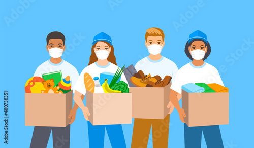 Young volunteers, boys and girls in masks stand and hold boxes with goods for charity such as food, clothes, shoes, toys. Charitable organization workers give humanitarian aid for people in need.