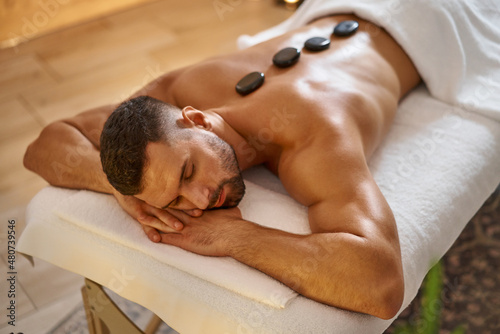 Man having lastone massage at spa salon photo