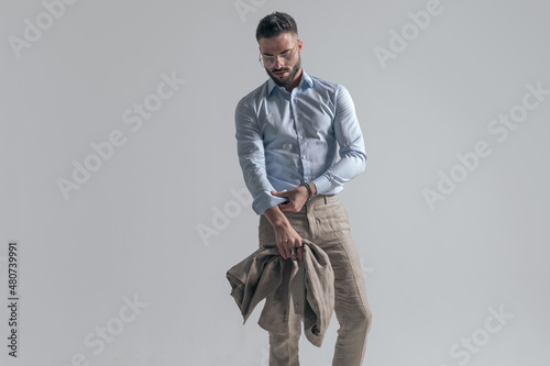 Foto cool fashion model adjusting sleeve and holding jacket