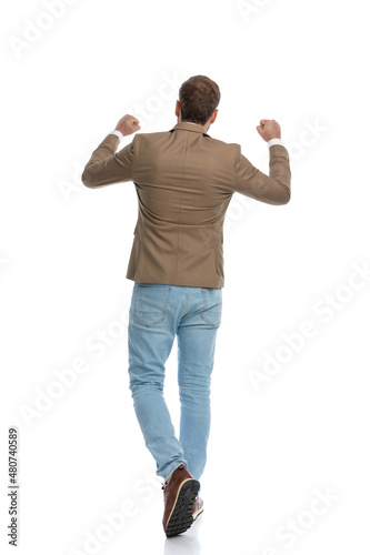 businessman walking away from the camera and celebrating success